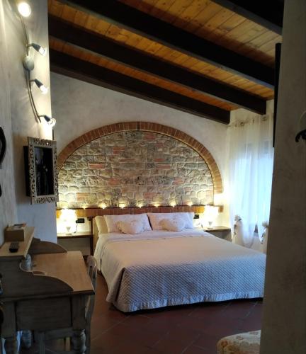 a bedroom with a large bed and a brick wall at Bed And Breakfast Olimpia in San Salvatore Monferrato