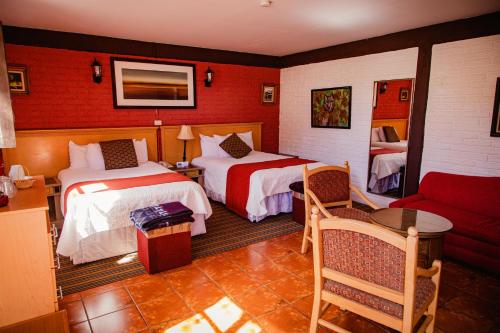 a hotel room with two beds and a couch at HOTEL BOUTIQUE EL VIEJO MUNDO in Hidalgo del Parral