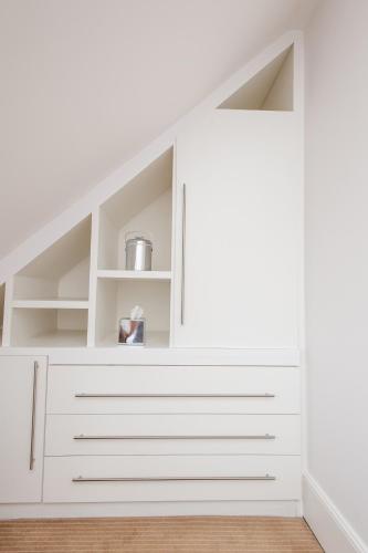 a room with white drawers and a white wall at Rewley House University of Oxford in Oxford
