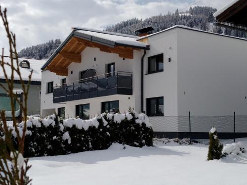 a white building with snow on the ground at M4 Appartements in Wagrain