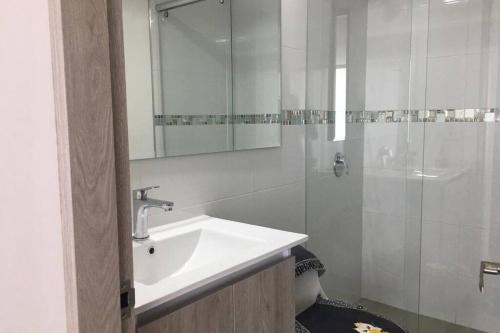 a white bathroom with a sink and a shower at Hermoso apartamento con estacionamiento gratuito Chía N1 in Chía