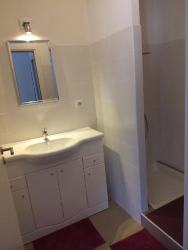 W białej łazience znajduje się umywalka i lustro. w obiekcie Lecci St Cyprien Don Andria w mieście Porto-Vecchio