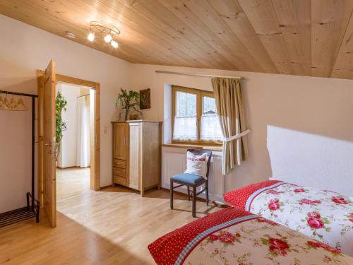 1 dormitorio con 1 cama y 1 silla en una habitación en Ferienwohnung Gasteiger, en Steinberg am Rofan