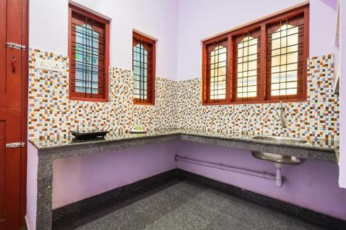 a bathroom with two sinks and two windows at CARMEL HOME STAY in Munnar