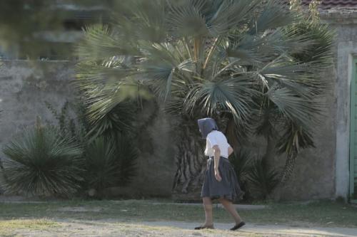 a woman walking in front of a palm tree at Apartment in Susak with air conditioning, W-LAN (3865-6) in Susak