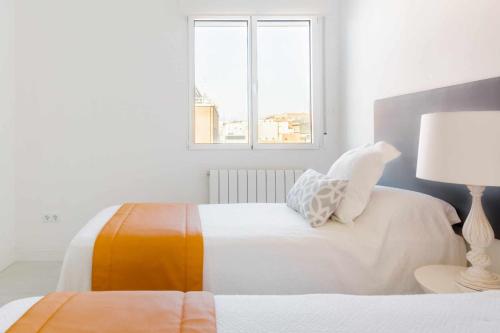 マドリードにあるEl Viso Smart IIIの白いベッドルーム(ベッド2台、ランプ付)
