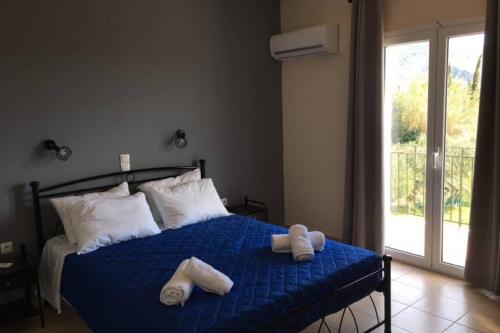 Un dormitorio con una cama azul con toallas. en Rodanthy I, en Katelios