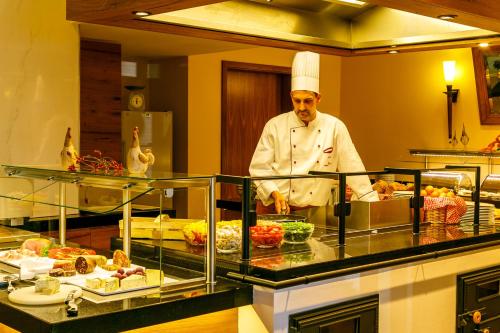 a chef standing in a kitchen preparing food at Hotel Zum Stein Wellness & Genuss Resort in Oranienbaum-Wörlitz