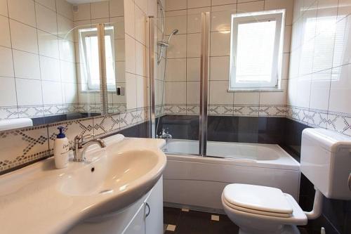 ein Badezimmer mit Waschbecken, Toilette und Badewanne in der Unterkunft Seaview Apartment Omisalj 3623-2 in Omišalj