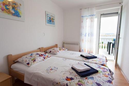 ein Schlafzimmer mit einem Bett mit zwei Handtüchern darauf in der Unterkunft Seaview Apartment Omisalj 3623-2 in Omišalj
