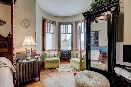 a living room with a mirror and a bedroom at Grandison Inn in Oklahoma City