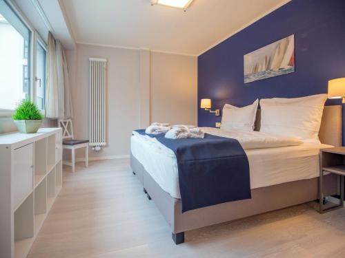 een slaapkamer met een groot bed met een blauwe muur bij Dünenresidenz Prora - Ferienwohnung mit Meerblick, 2 Schlafzimmern und Loggia NP-318 in Binz
