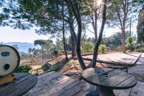 two wooden benches sitting on a wooden table in a park at La Maison Fratelli in Hyères