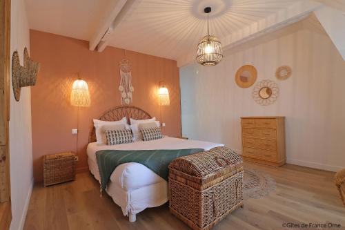 a bedroom with a bed and a chair and lights at La Grange Bagnolaise in Bagnoles de l'Orne