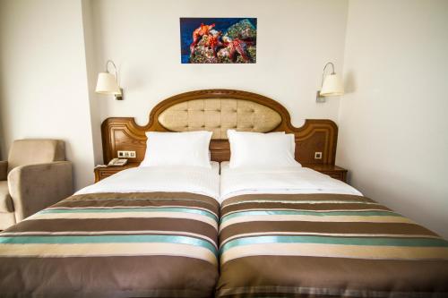 1 dormitorio con 1 cama grande y 2 almohadas en Sea Star Marmaris - Adult Only, en Marmaris