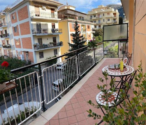 - un balcon avec une table, des chaises et des bâtiments dans l'établissement A Casa e' Mammà, à Sorrente