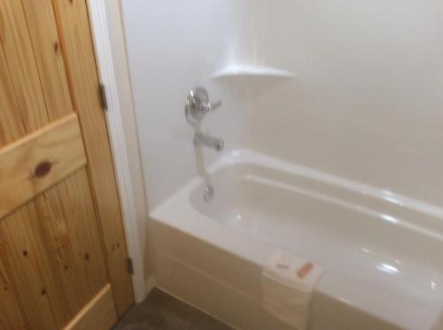 a white bath tub with a faucet in a bathroom at Denali Fireside Cabin & Suites in Talkeetna