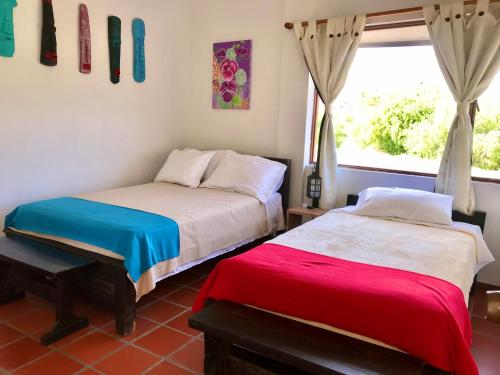 two beds in a room with a window at Villa del Sol - Apartamentos Turísticos in Sáchica