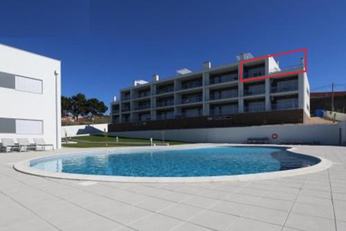 een gebouw met een zwembad voor een gebouw bij Pearl of Nazaré in Nazaré