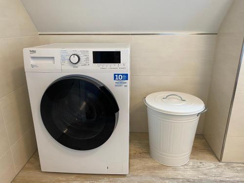 a washing machine and a trash can in a room at Ferienwohnung Olli Koch in Reken