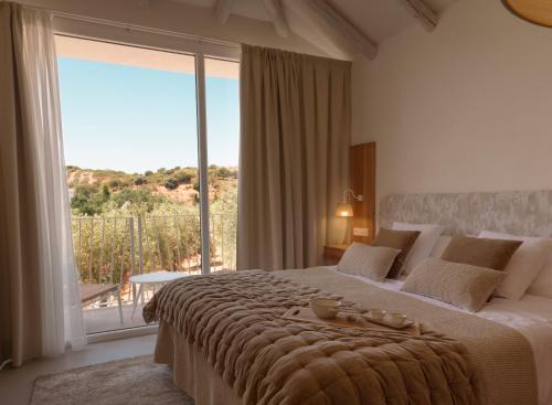 Un dormitorio con una cama grande con una ventana grande. en Hacienda Fresneda María by Charming Stay Adults Recommended, en Villanueva del Rosario