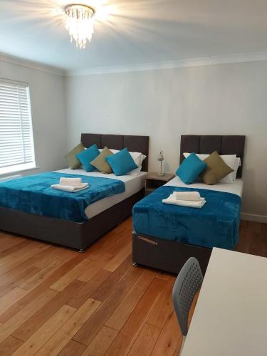 a bedroom with two beds and a table at Central Ashford Stay - Contractors & Families Welcome - Free Parking in Kent