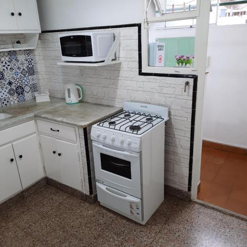 a small kitchen with a stove and a microwave at Piazza Mendoza in Mendoza