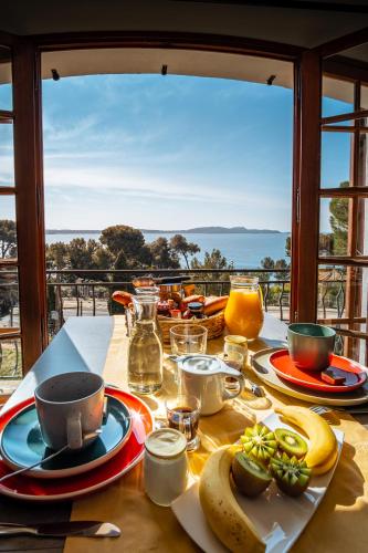 a table with plates of food and a view of the ocean at La Maison Fratelli in Hyères