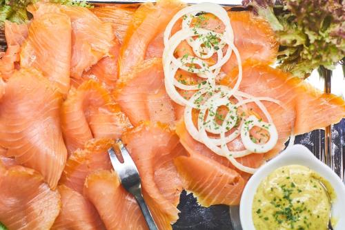 a plate of food with fish and onions on it at Hochwald Lodge in Morbach