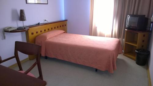 a hotel room with a bed and a tv at Hotel Montmeló in Montmeló