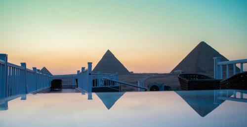Una vista de las pirámides desde el tejado de un edificio. en Marvel Stone Hotel, en El Cairo