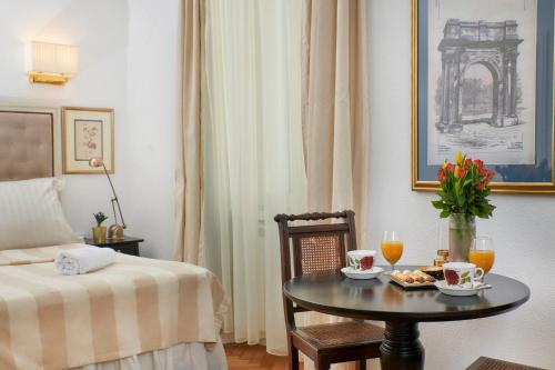Casa Dei Fiori في بولا: غرفه فندقيه بطاوله وسرير