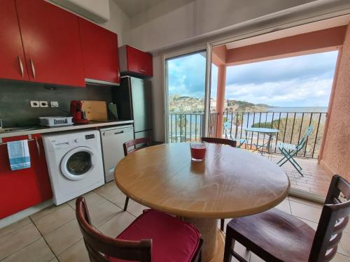 Il comprend une cuisine avec une table et un balcon. dans l'établissement Appartement VUE MER TERRASSE CLIM WIFI, à Banyuls-sur-Mer