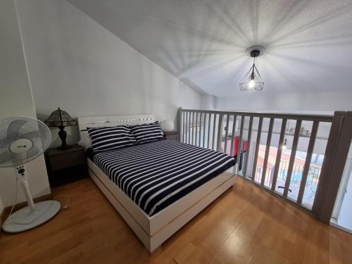 a bedroom with a bed with a black and white striped sheets at Appartement VUE MER TERRASSE CLIM WIFI in Banyuls-sur-Mer