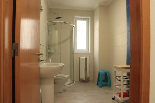 a bathroom with a sink and a toilet and a window at Faial Marina Apartments 2 in Horta