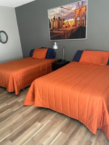 um quarto com duas camas e um quadro na parede em Motel Populaire em Trois-Rivières