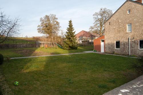 a yard with a building and a soccer ball on the grass at Chambres d'hôtes de la Quairelle in Gerpinnes