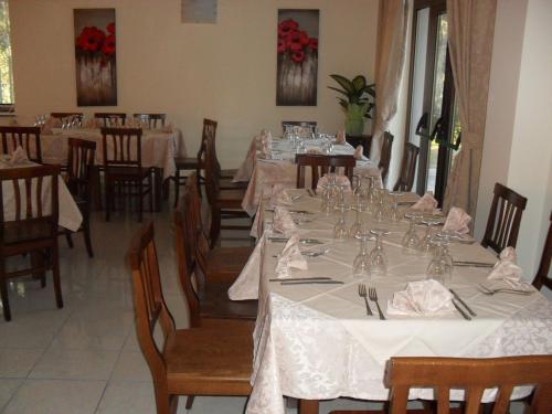 a dining room with tables and chairs with white tablecloths at Hotel Giardino San Michele in Vallo della Lucania