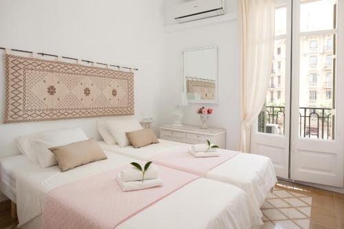 two beds in a white room with plants on them at Casa Muntaner in Barcelona
