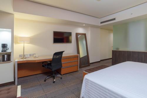 a hotel room with a desk and a bed at Holiday Inn Mexico City-Plaza Universidad by IHG in Mexico City