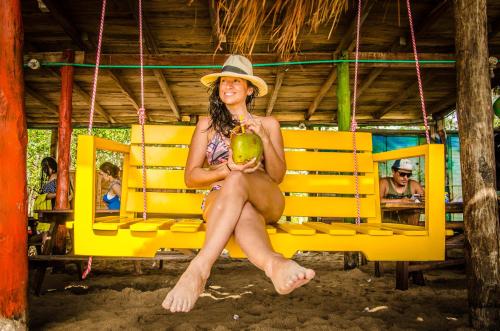 a woman in a hat sitting on a yellow bench at Nuestros Tres Tesoros II in Playa Blanca