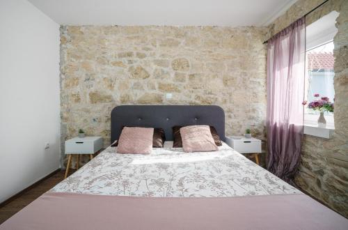 a bedroom with a large bed with pink pillows at GRANDMA´S HOUSE in Stankovci