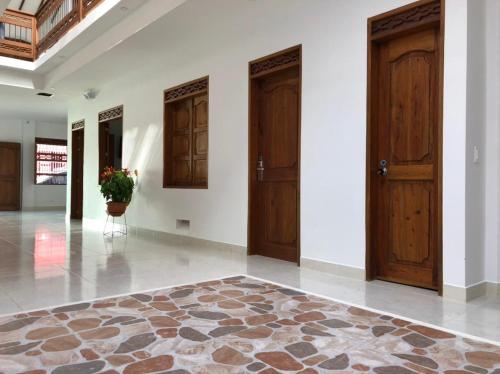 a hallway with two wooden doors and a potted plant at Casa Isabel Hotel in Jardin