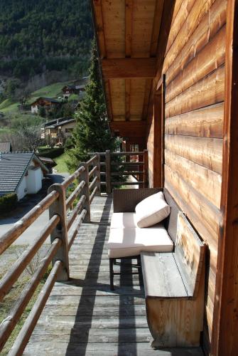 a wooden porch with a bench on a deck at Chalet Edelweiss - Verbier, Mountain Views, Jacuzzi! in Vollèges