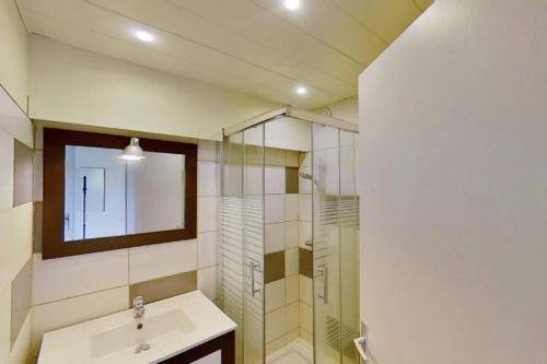 une salle de bain avec un lavabo et une douche en verre dans l'établissement Les Goelettes - Appartement en RDC avec accès direct à la plage, à Saint-Cyprien