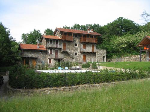 a large stone building with a pool in front of it at Casale Antico Borgo in Colico