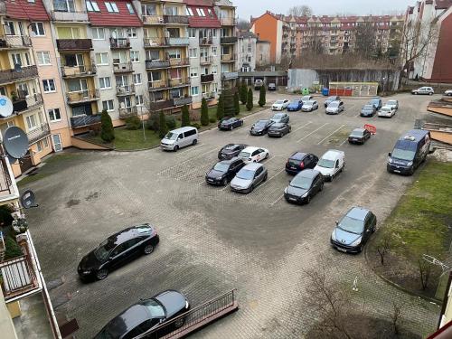 a bunch of cars parked in a parking lot at Apartament Dwupoziomowy - klimatyzacja in Słupsk