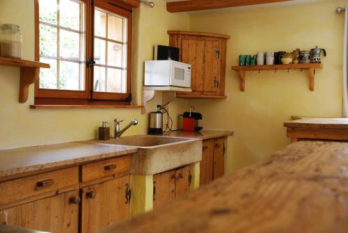 a kitchen with a sink and a microwave at Chalet Edelweiss - Verbier, Mountain Views, Jacuzzi! in Vollèges