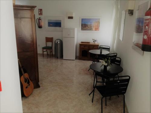 ペレジョにあるPension Subirats Perelloのテーブルと椅子、冷蔵庫が備わる客室です。
