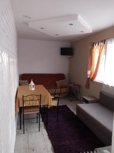 een woonkamer met een tafel en een bank bij domek Boszkowianka Mini in Boszkowo